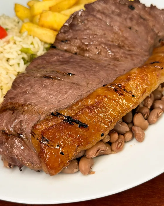 Prato de carne grelhada com feijão e fritas